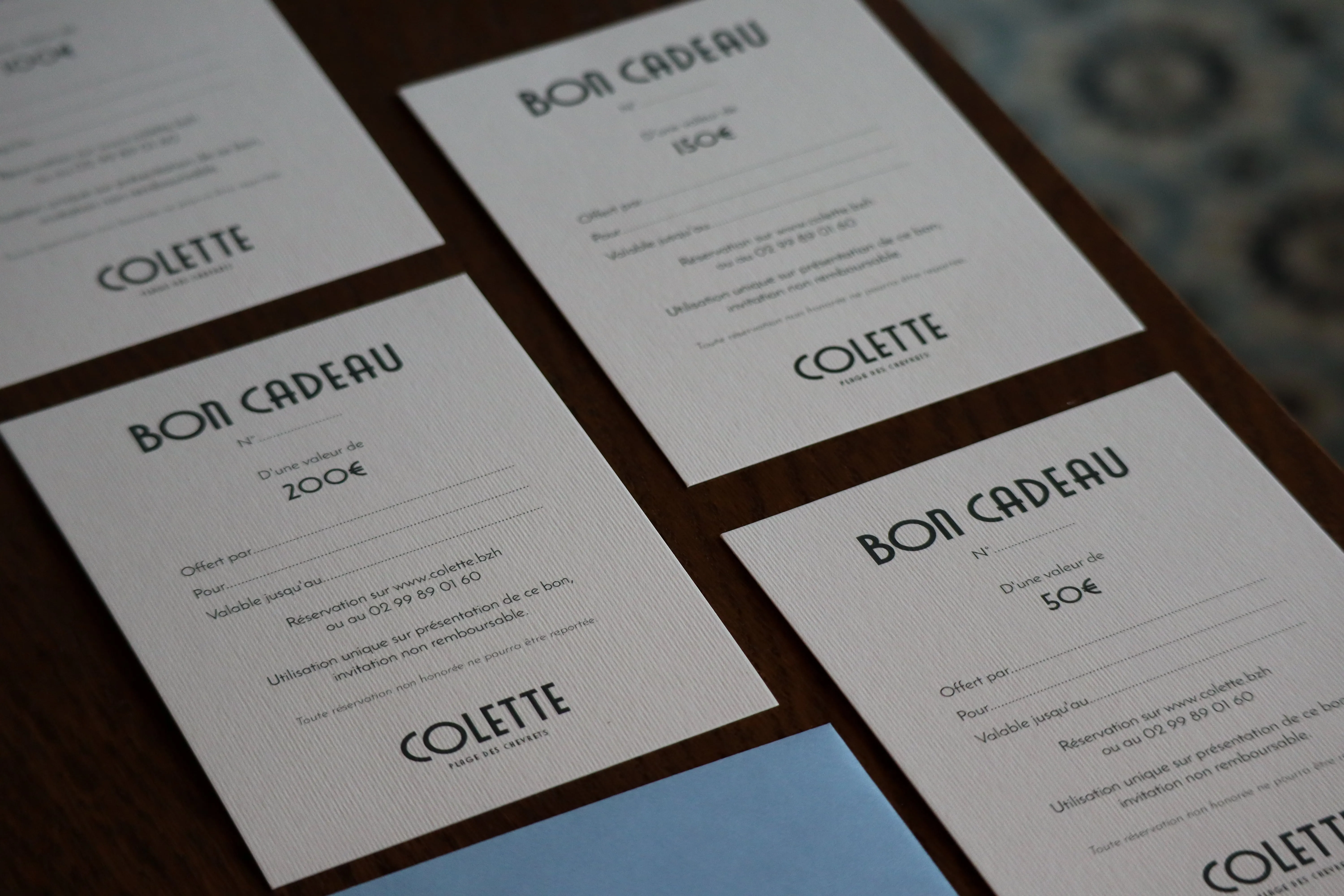 Les bons cadeaux Colette en papier, cartes posées en éventail sur une table