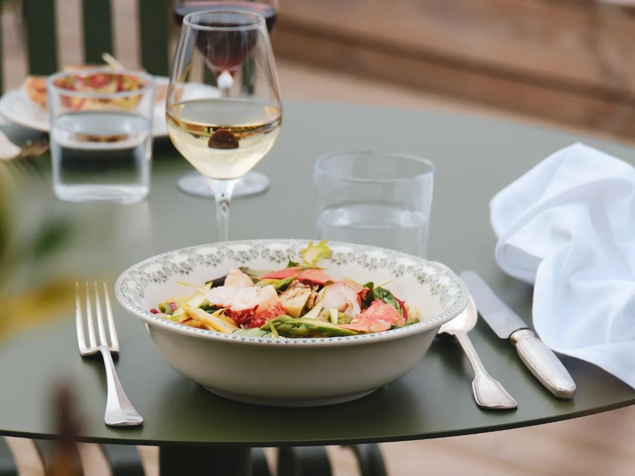 Déjeuner en terrasse, verres de vin blanc face à la mer