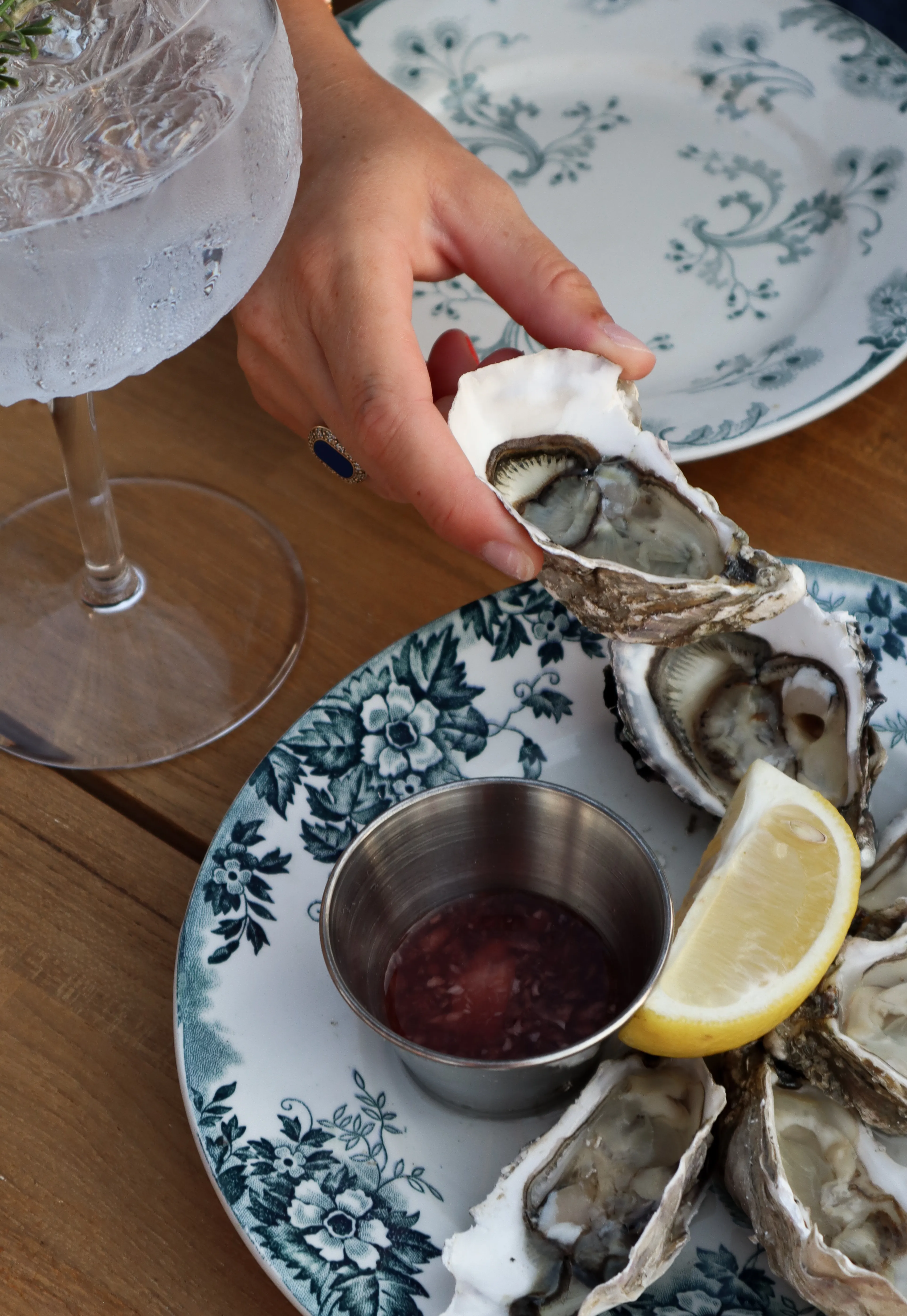 Huîtres servies sur assiette de faïence bleue, citron et vinaigre à l'échalote