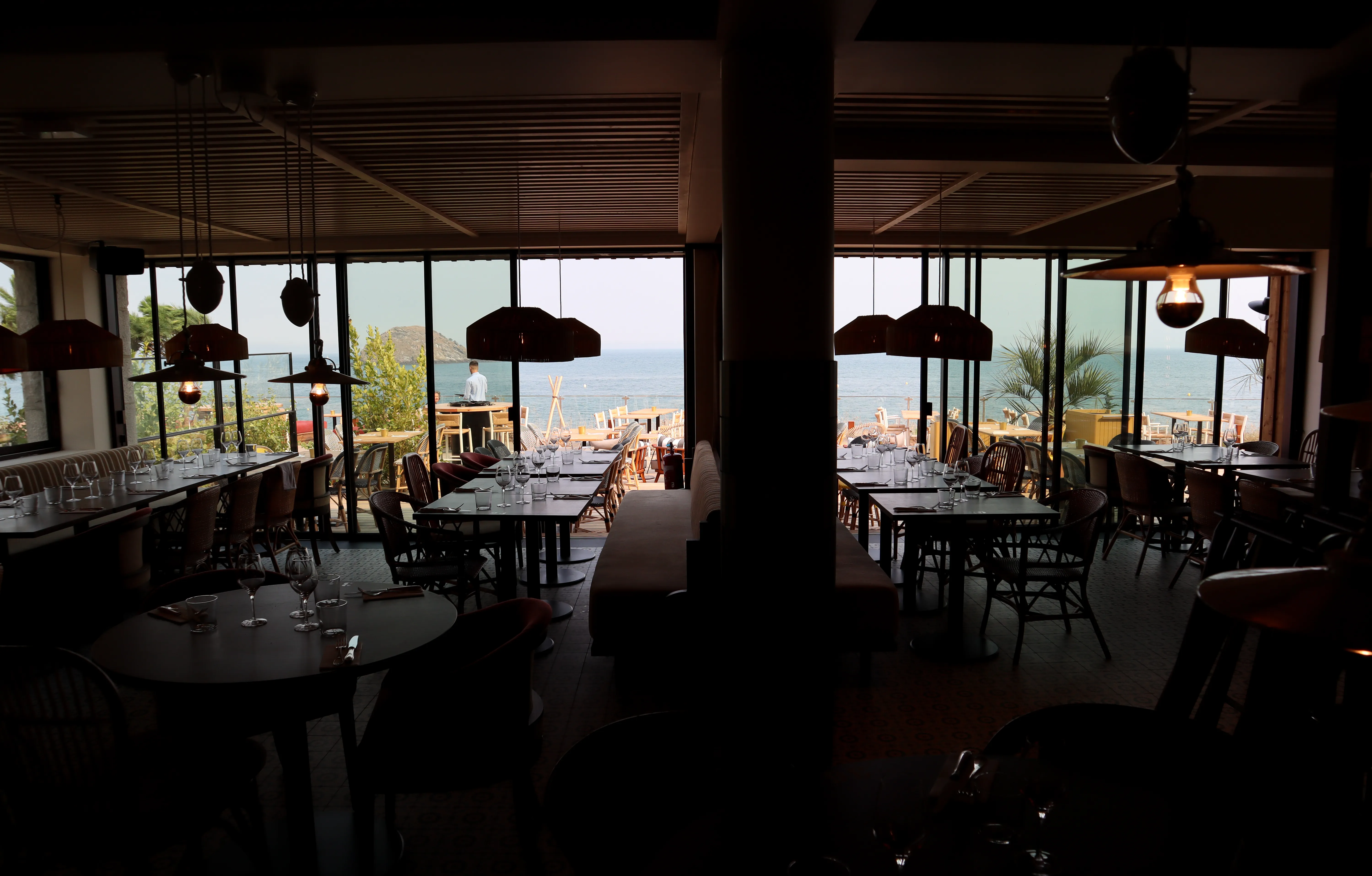 La salle de Colette, tables dressées et grandes baies ouvertes sur la mer