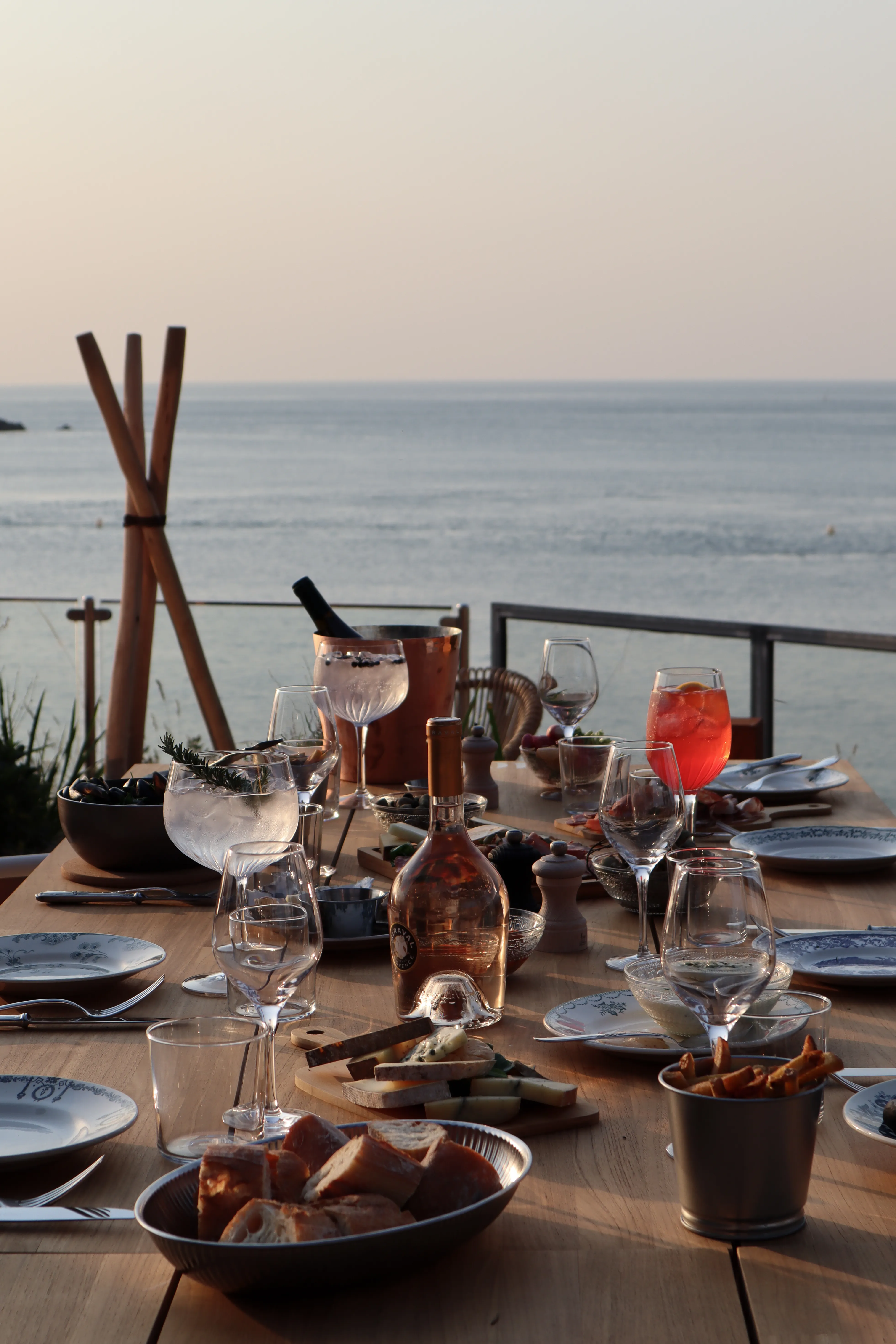 Dîner en terrasse au soleil couchant, la mer à l'horizon